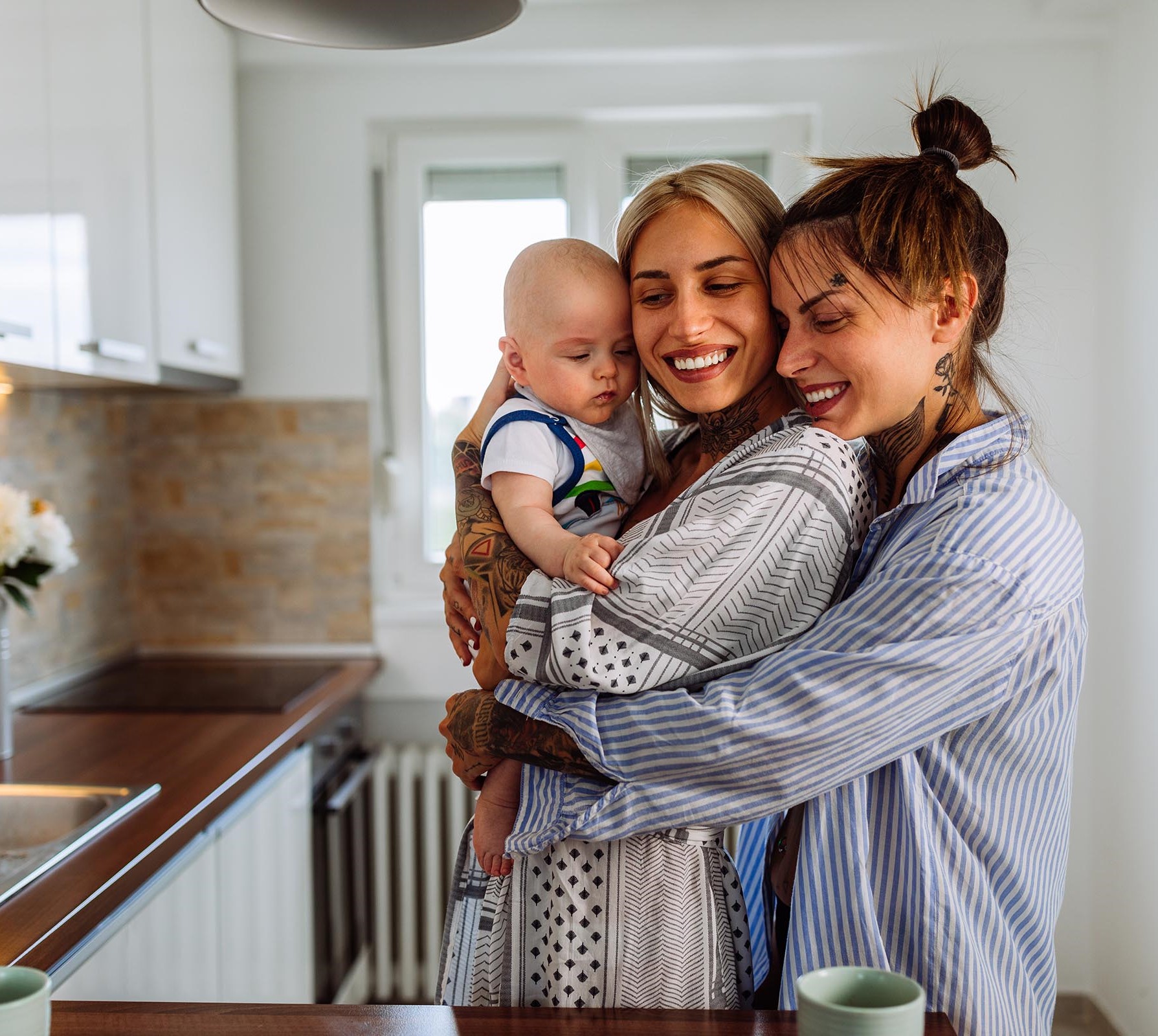 Young LGBT family spending time together with infant.