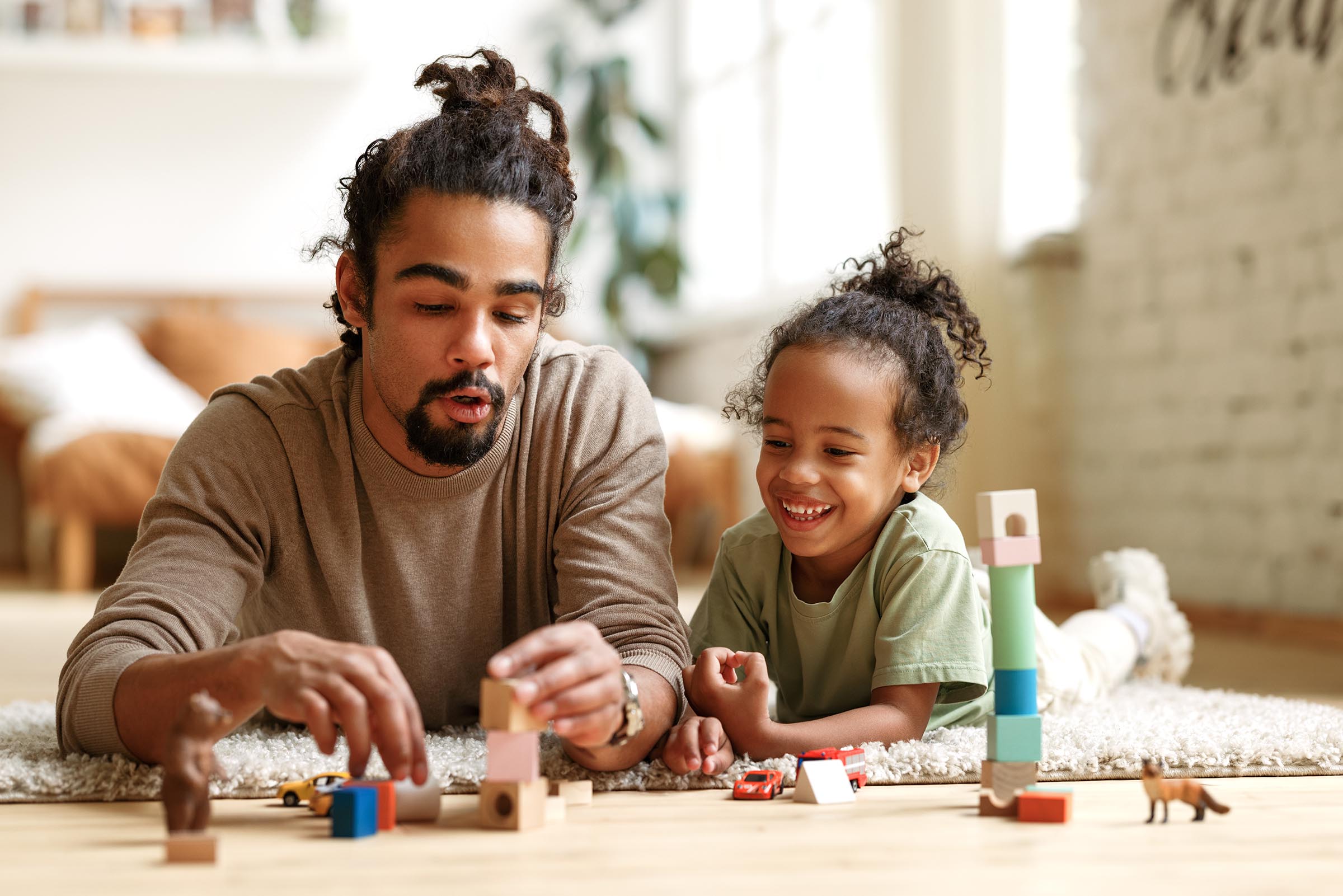 young african amercian father playing blocks with daughter