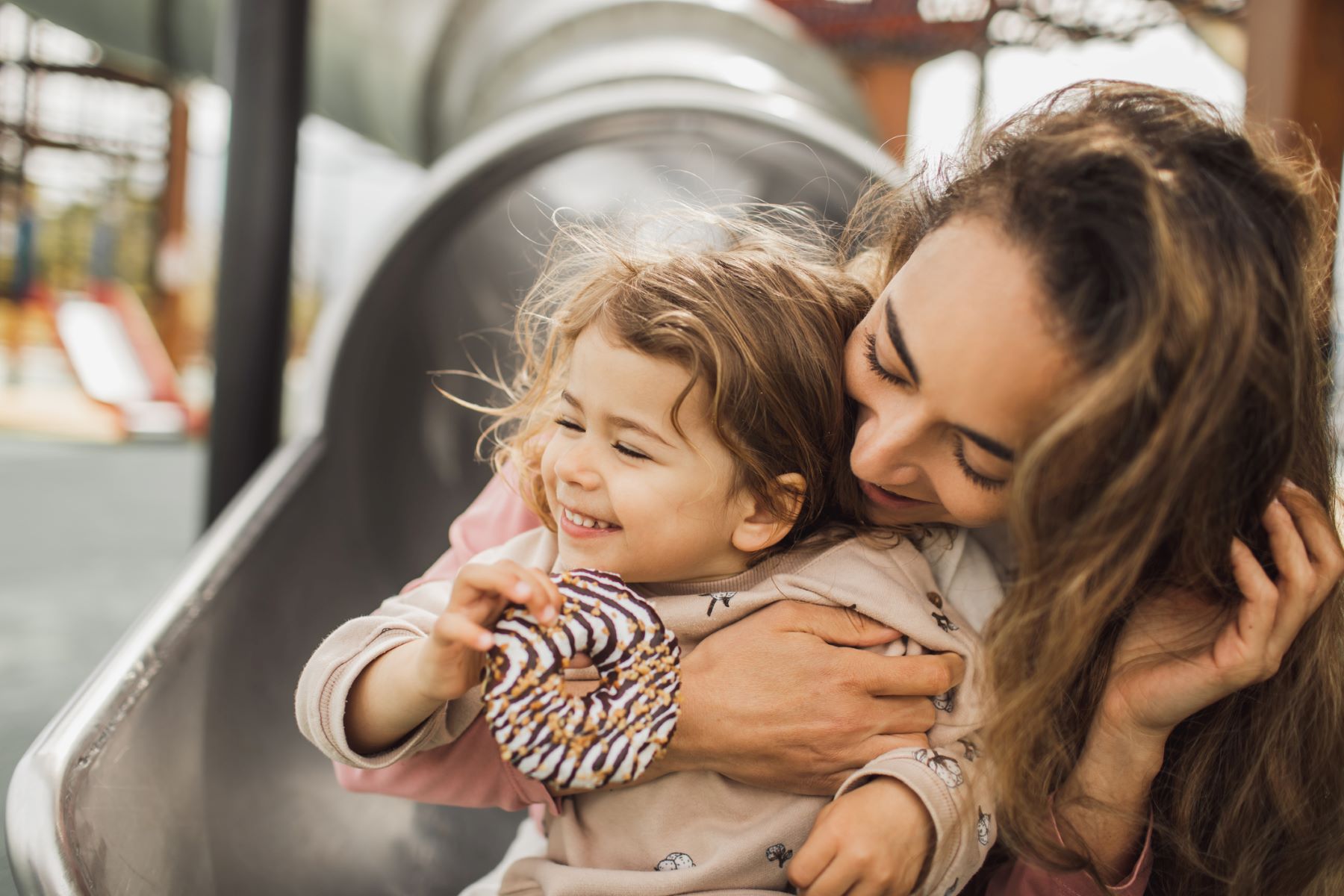 Smiling mom and young girl enjoying a donut