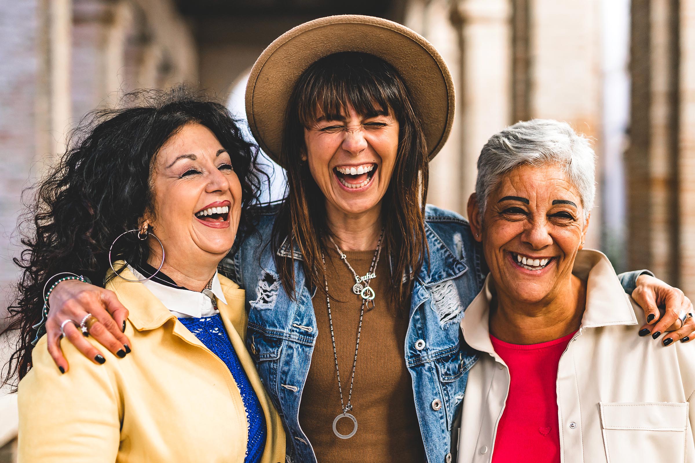 Three women friends hugging and laughing