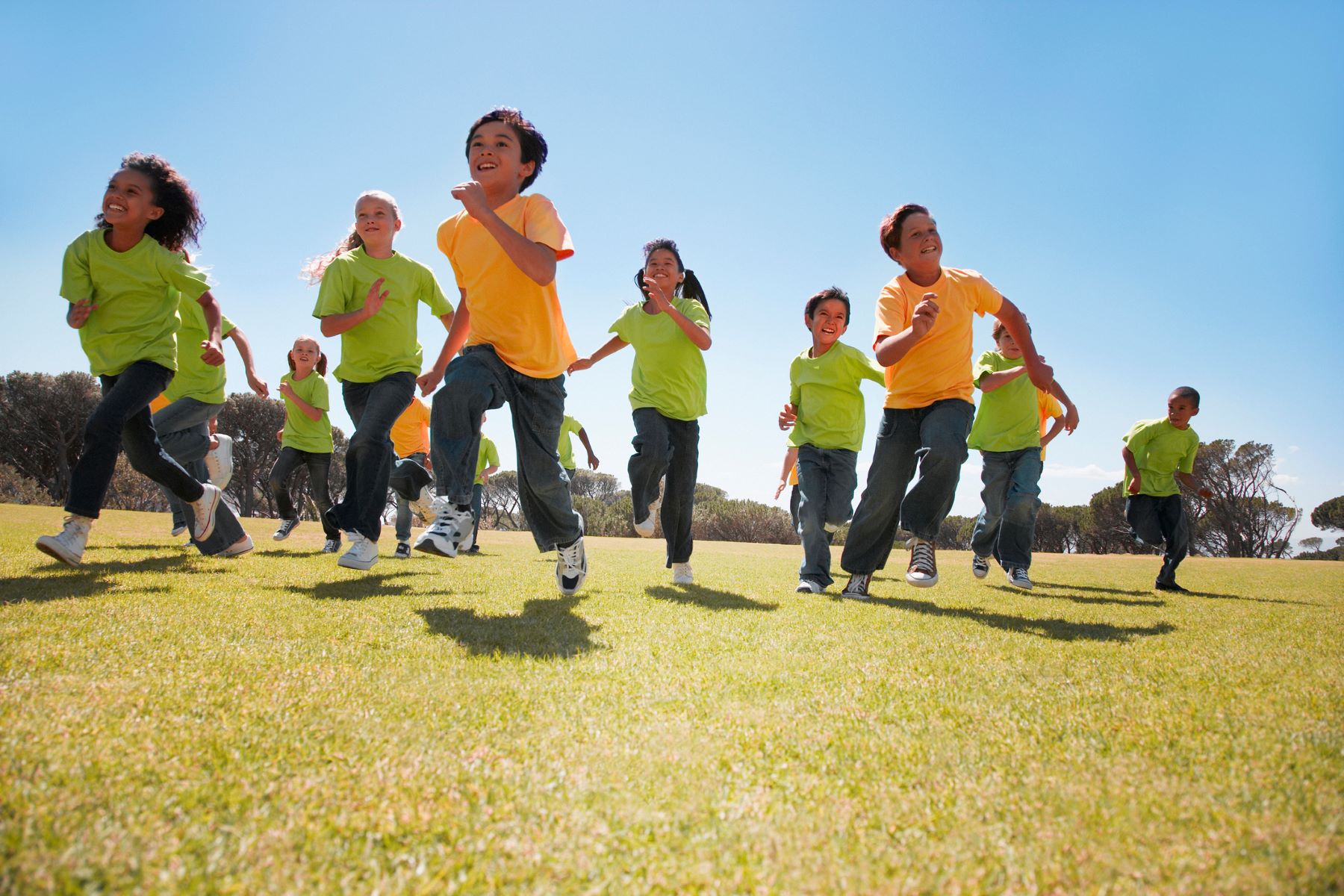 group of laughing children running in the sun