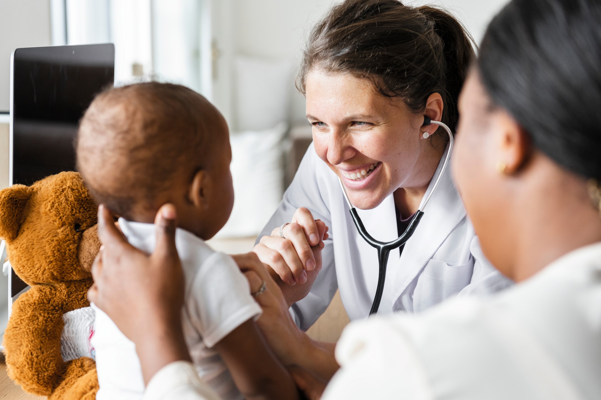 Smiling doctor examining a baby