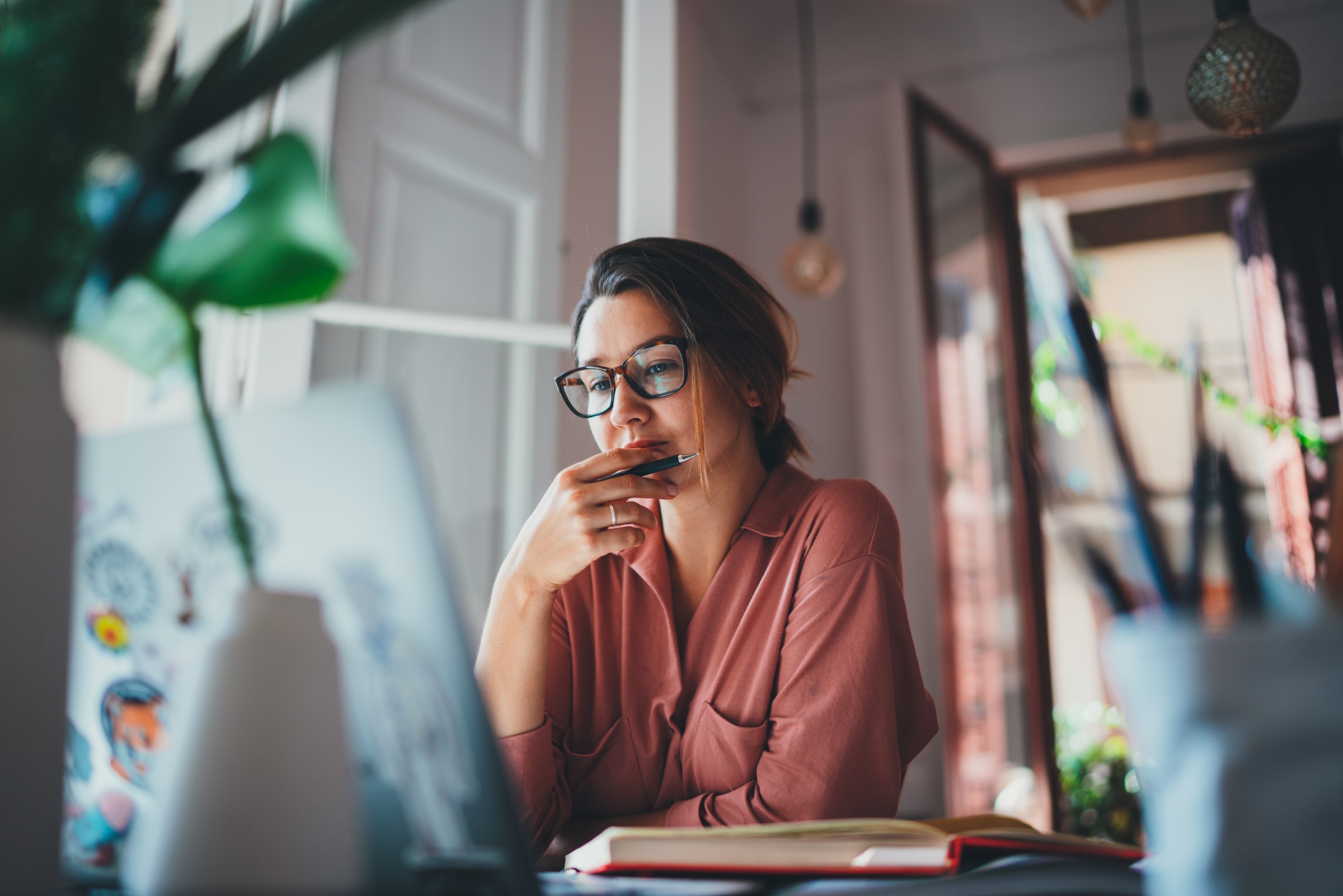 woman looking thoughtfully at her computer