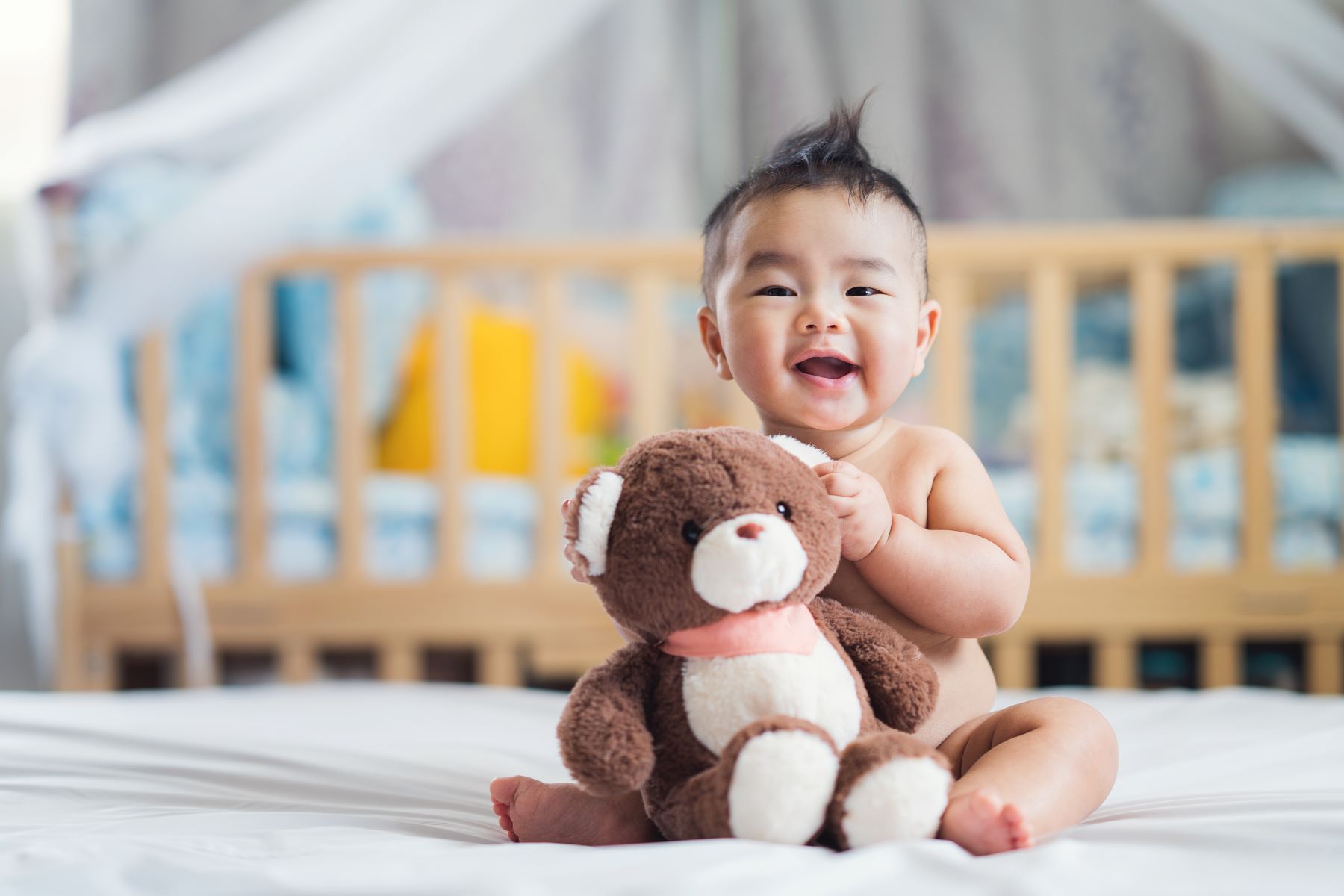 smiling baby holding a teddy bear